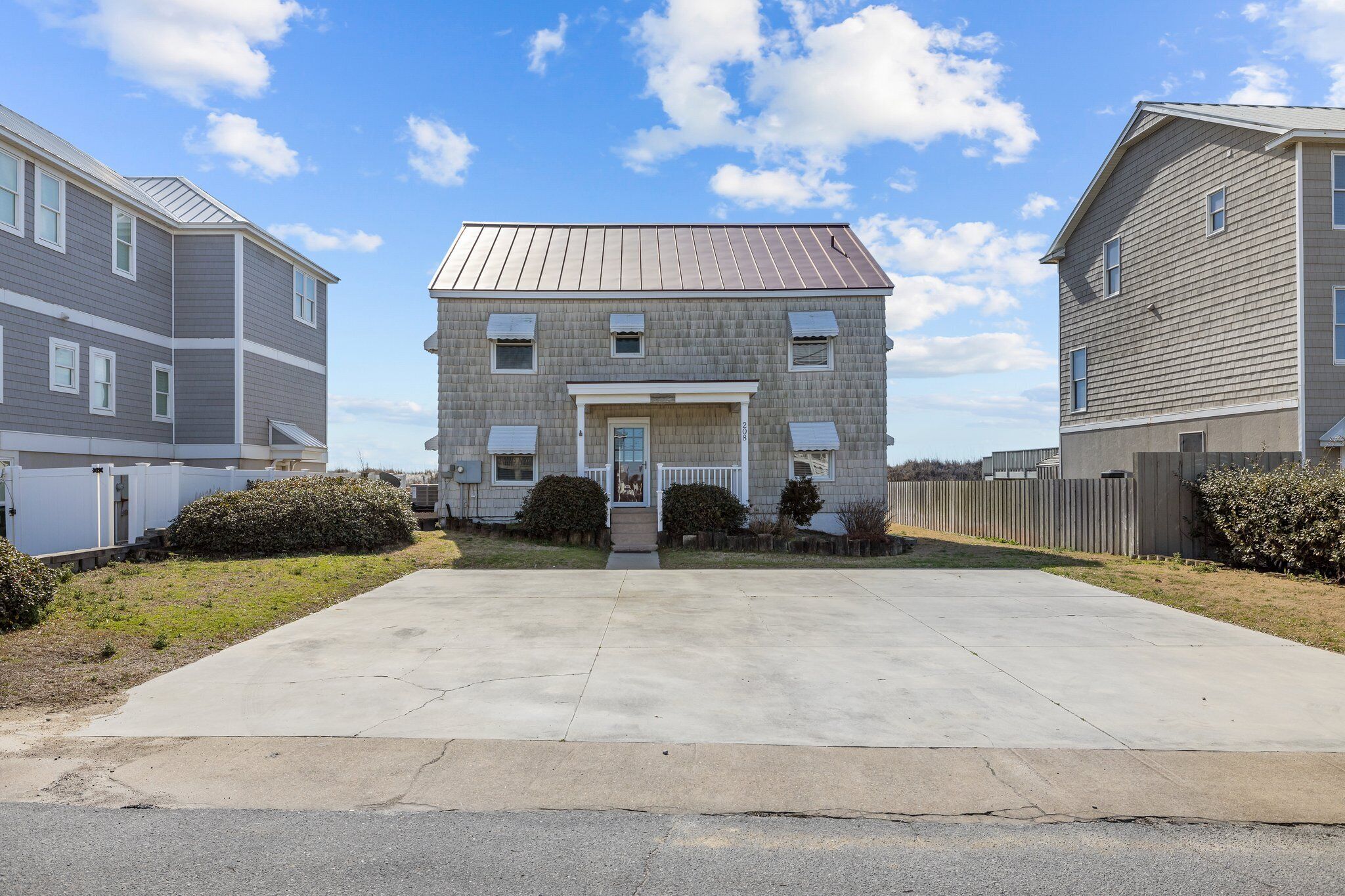 A two-story residential building with a front entrance, a small porch, and a garage on the left.