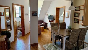 Una habitación con una mesa de comedor, sillas, un televisor y un sofá.