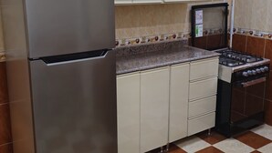 Une cuisine équipée d’un réfrigérateur, d’une cuisinière, d’un four à micro-ondes et de placards.