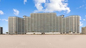 A large, multi-story hotel with a modern architectural design, featuring a flat roof and extensive use of glass windows.