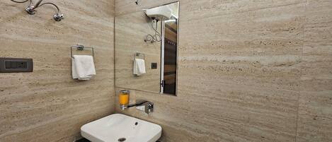 A modern bathroom with a white sink, a mirror, and a towel rack.