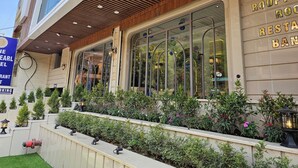 A modern building with a restaurant named "Rooftop Restaurant" on the ground floor. - The Blu Pearl (Gwalior)