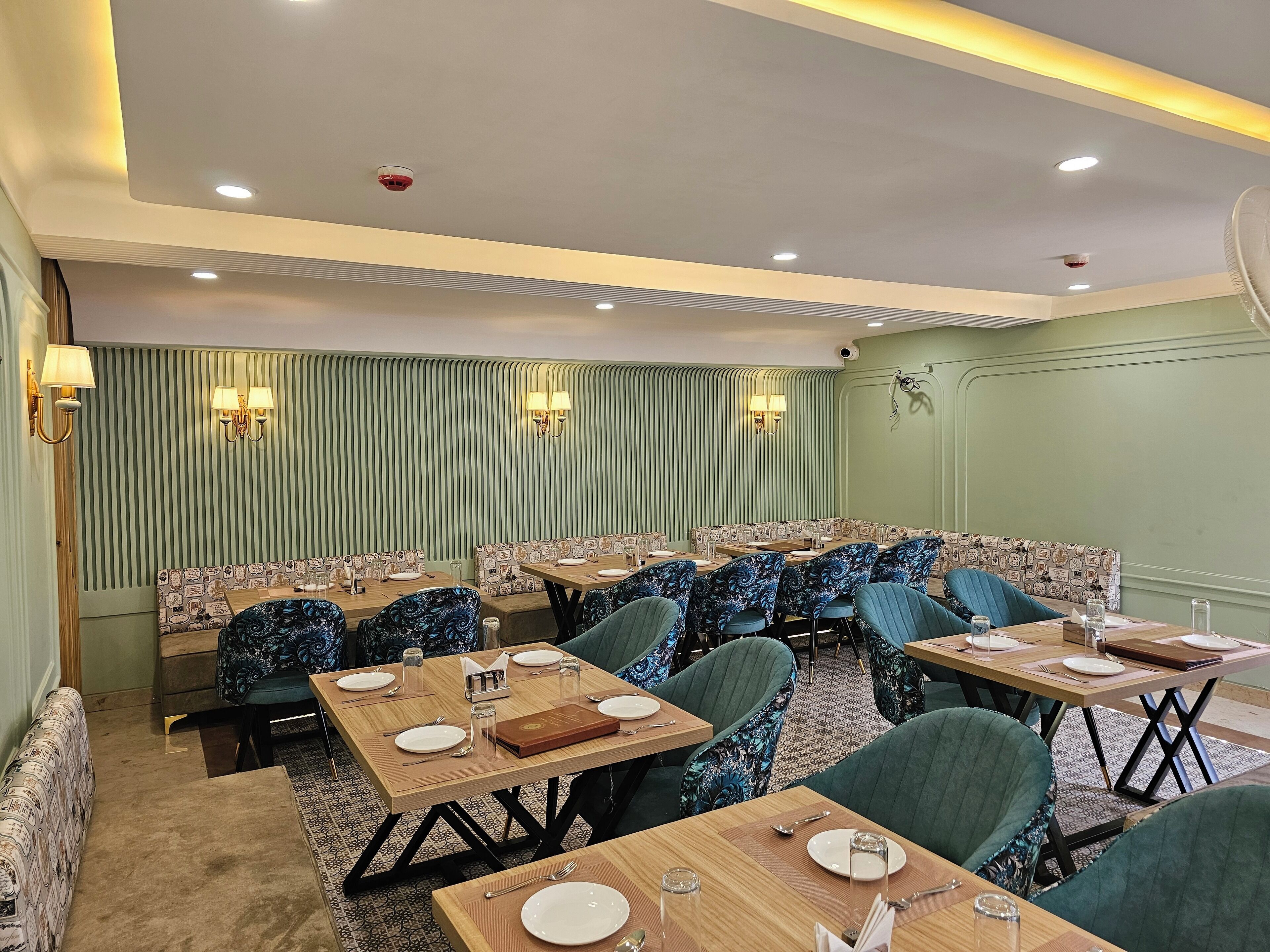 A restaurant with multiple dining tables and booths, equipped with table settings and chairs.