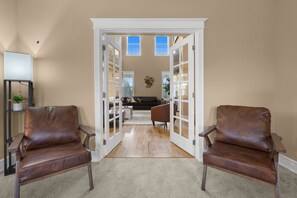 Un salon spacieux avec un plafond haut, une grande fenêtre et une vue sur l’extérieur.