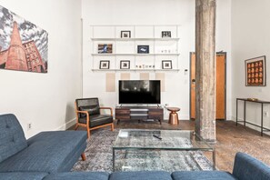 A modern living room with a flat-screen TV, a coffee table, and two sofas. - Pet Friendly | King Bed | Beltline Access (Atlanta)
