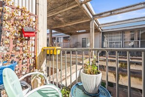 A balcony with a metal railing, potted plants, and a red mailbox labeled "Rock City". - Pet Friendly | King Bed | Beltline Access (Atlanta)