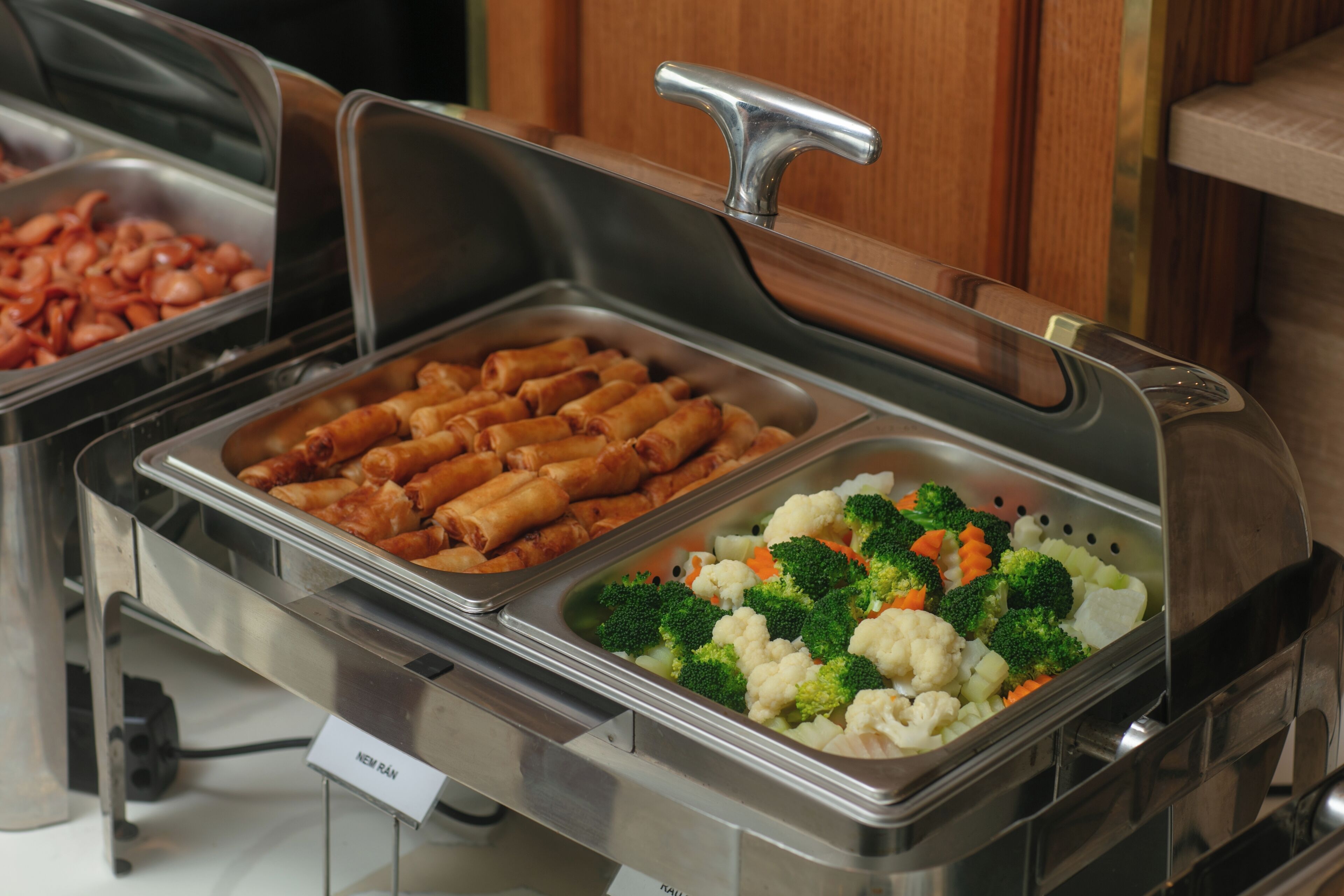 A buffet with labeled sections for different food items.