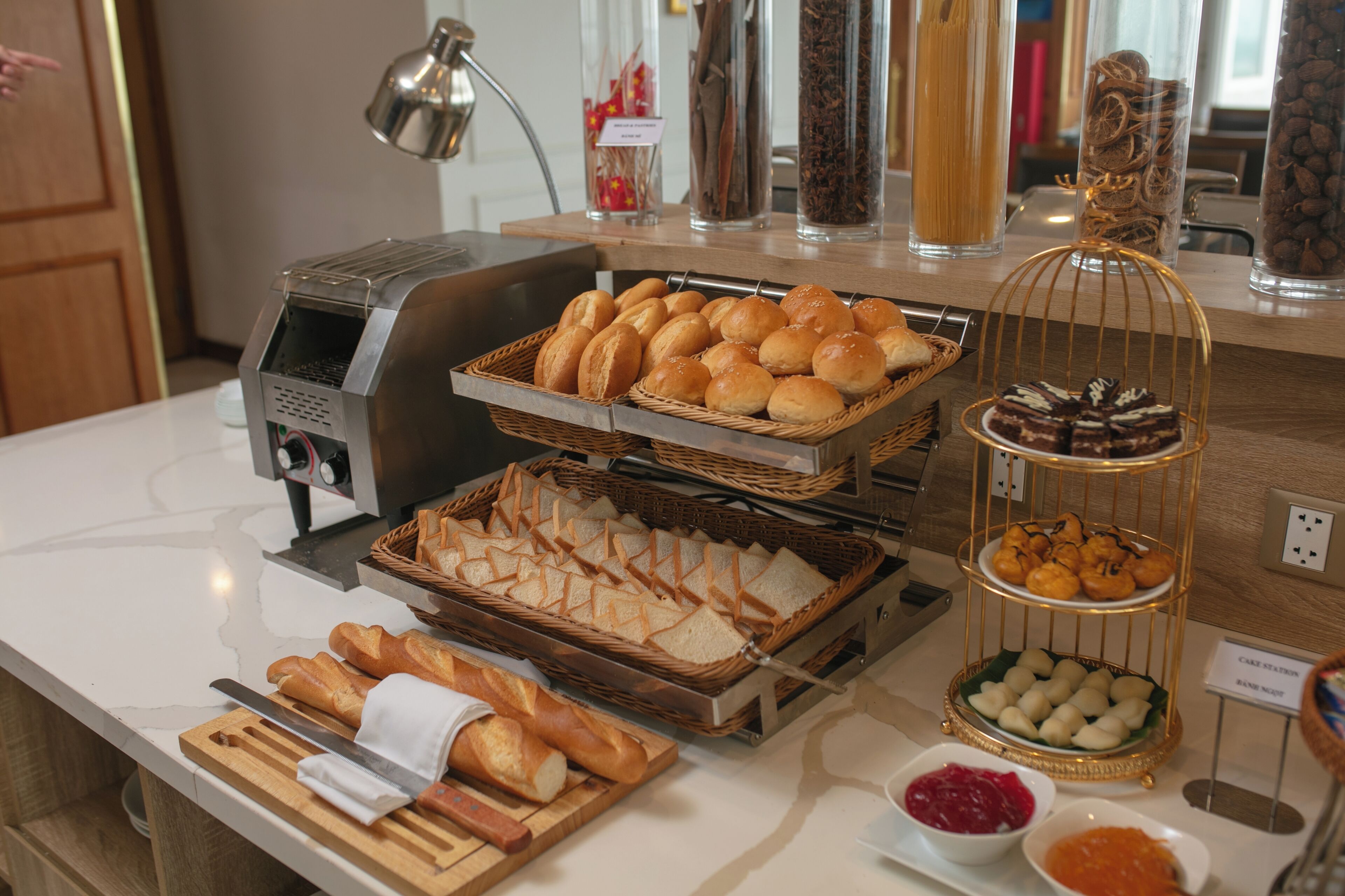 A buffet with various breads, pastries, and a coffee machine.