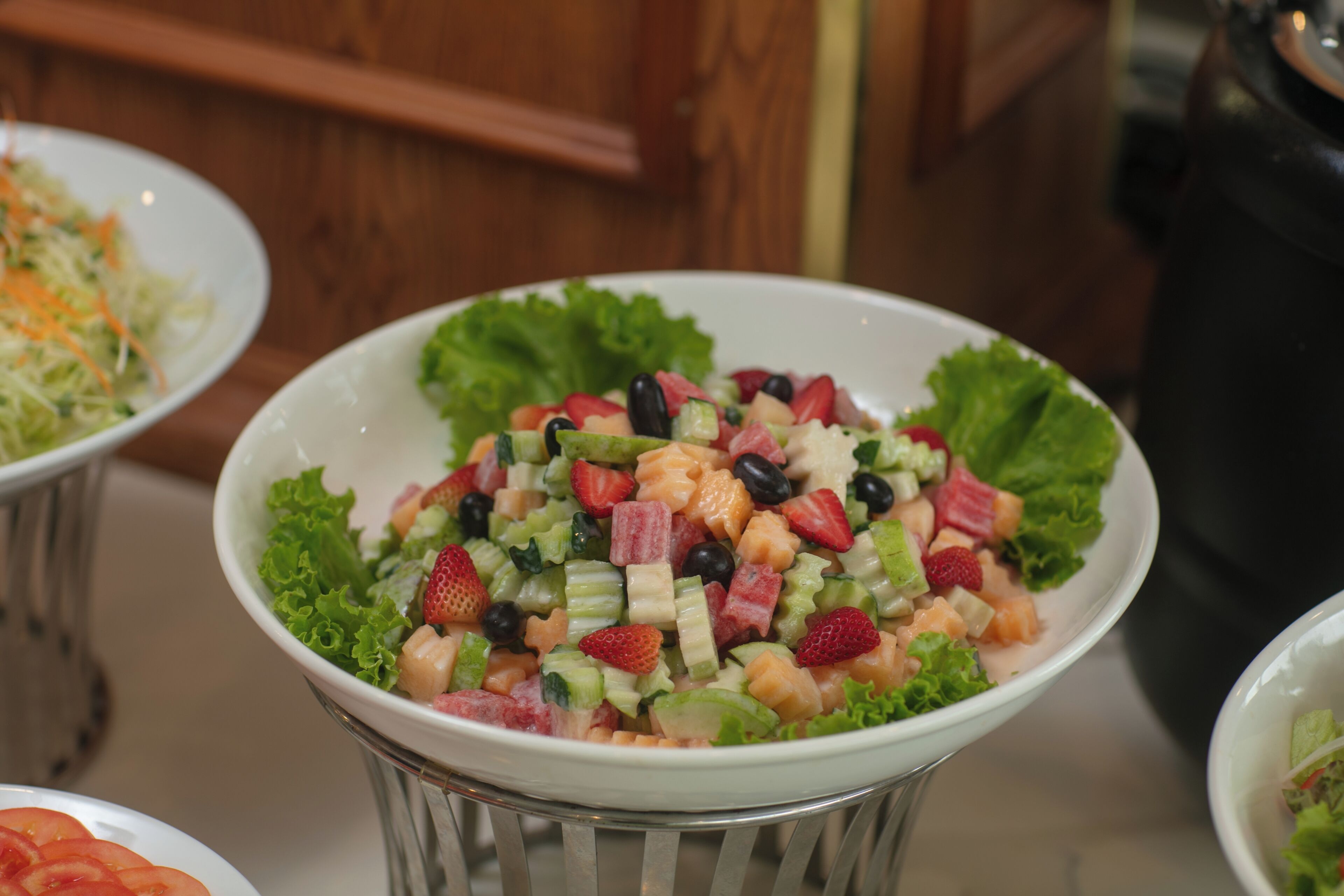 A bowl of fruit salad with various fruits and vegetables.