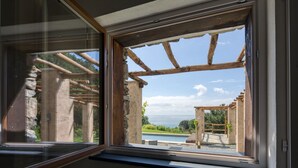 Una ventana con vista a una pérgola de madera y una piscina.