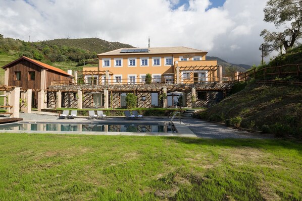 A hotel with a pool, outdoor seating, and a stone bridge. - Mirandola Suites (Arenzano)