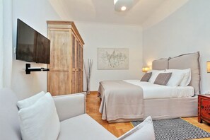 A modern bedroom with a bed, a sofa, a TV mounted on the wall, and a wooden wardrobe. - 2 apartments in the same building 2+3 (Spanish steps) (Roma)
