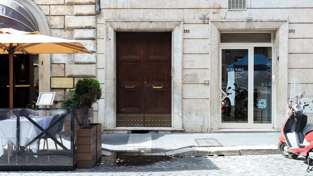 A building with a large wooden door, numbered 252, and a shop with a sign for 'Juma Nails'. - 2 apartments in the same building 2+3 (Spanish steps) (Roma)