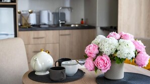 A kitchen with wooden cabinets, a sink, and a countertop with various items. - Zenao Appart'hôtels Toulouse Balma (Balma)