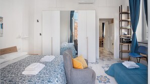 Een moderne hotelkamer met een groot bed, een bank, een bureau en een kledingkast.