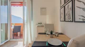 Zona pranzo con tavolo apparecchiato per due, vista sull'esterno e menu appeso al muro.