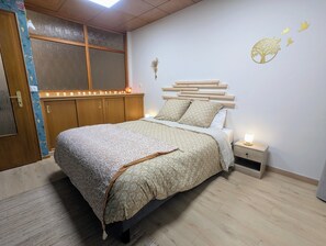 A bedroom with a bed, bedside table, and a window with curtains. - Les Ateliers Saverne (Saverne)