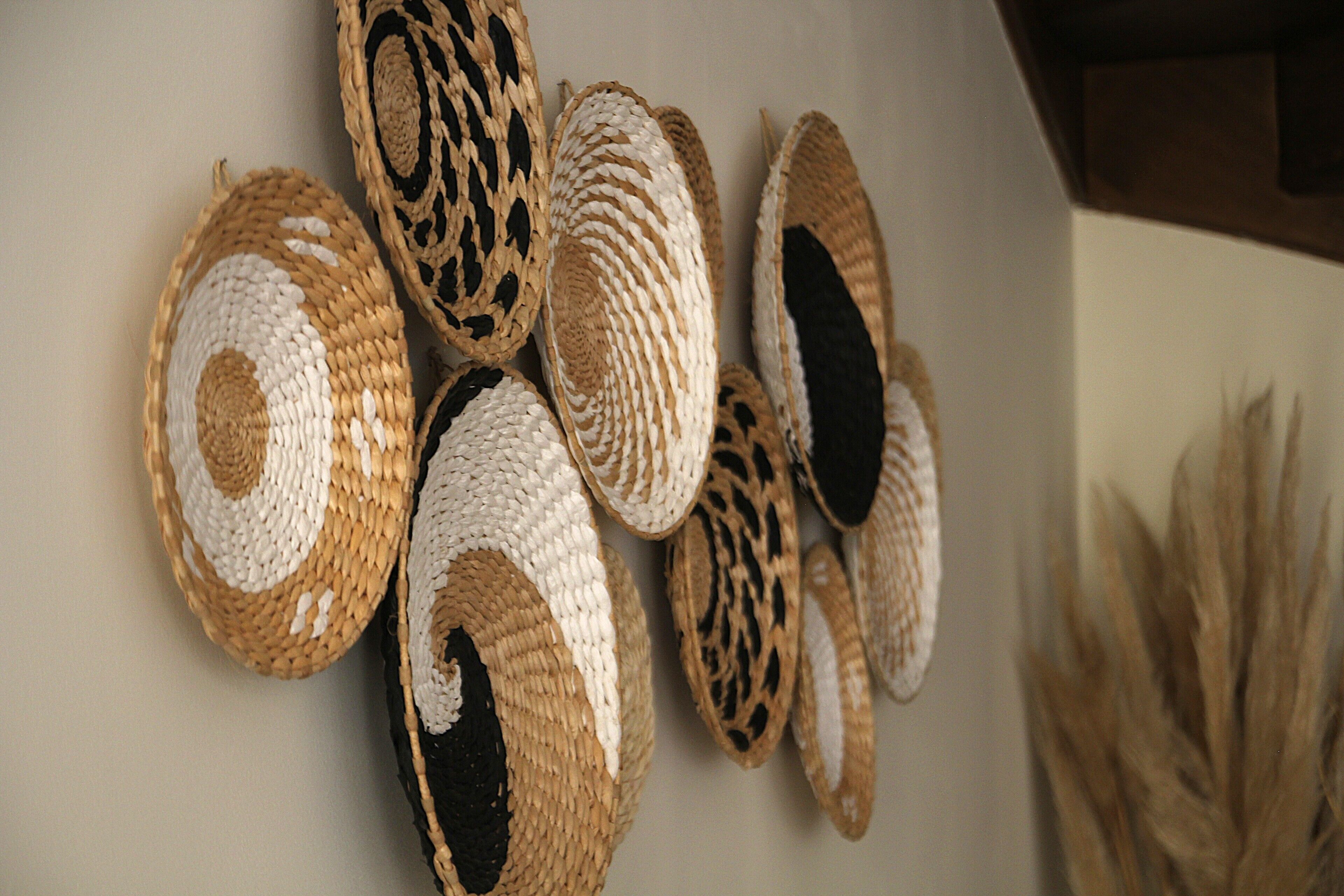 A wall with several woven baskets of different sizes and patterns.