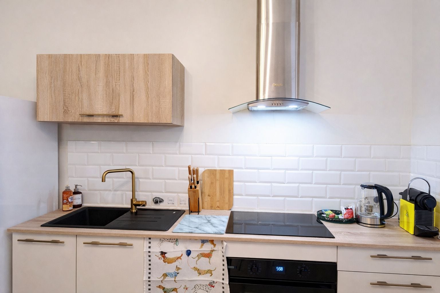 A kitchen with two sinks, a stainless steel range hood, and a dishwasher.