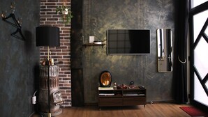 A modern living room with a brick wall, a large flat-screen TV, a wooden cabinet, and a hanging plant.