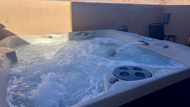 A hot tub with a view of a desert landscape.