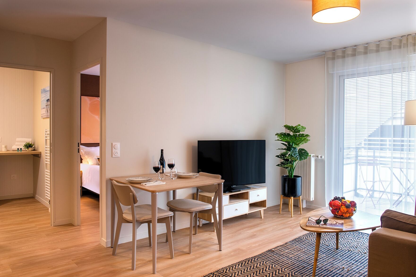 Un salon moderne avec une table à manger, un téléviseur et une plante en pot.