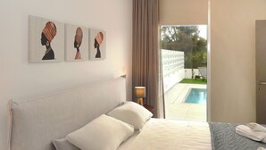 Una habitación de hotel con una cama, una mesita de noche, una lámpara y obras de arte en la pared.