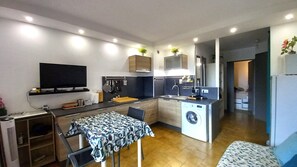 Enjoy a compact kitchen, dining area, and cozy living space with an oven, microwave, and flat-screen TV.