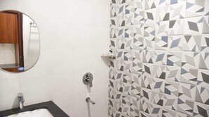 Un bagno con un lavandino nero, uno specchio e una parete con motivo geometrico.