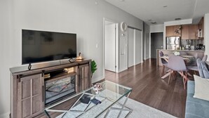 A modern living room with a flat-screen TV, a glass coffee table, and a fireplace. - GLOBALSTAY Modern 1BD+Den Condo w/ Balcony Lillian St (Toronto/Canada)