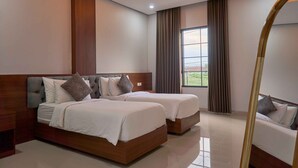 A modern hotel room with a large bed, two bedside tables, a mirror, and a window with curtains. - Sakanti Inn Wonosobo (Wonosobo)