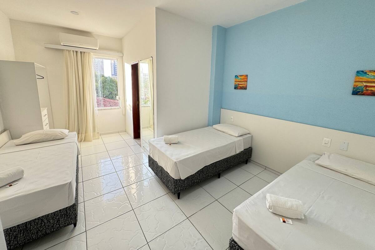Ein Hotelzimmer mit zwei Betten, einem großen Spiegel und Blick nach draußen.