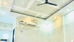 Una habitación con cama, ventilador de techo, equipo de aire acondicionado, lavabo y espejo.