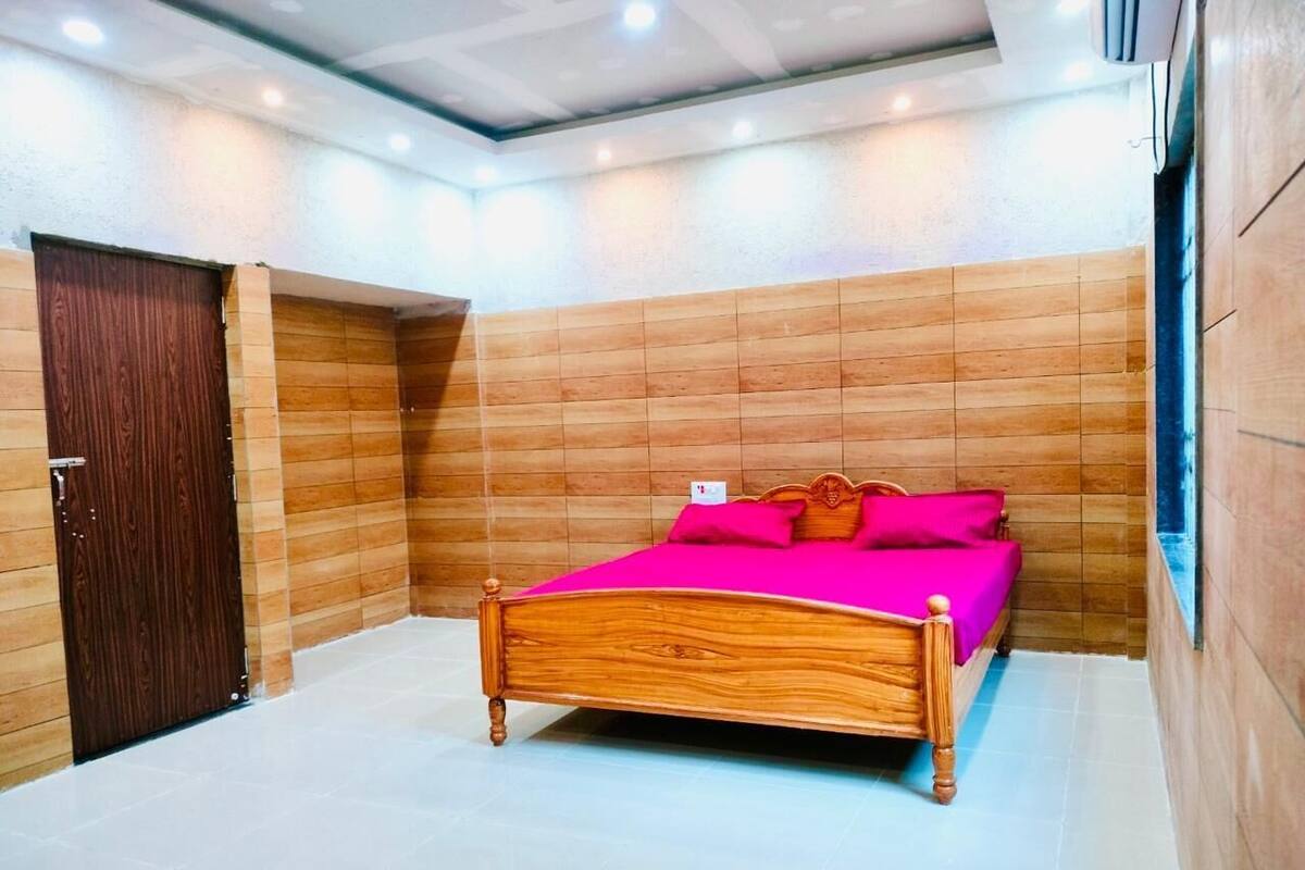 A bedroom with a wooden bed, a wooden wardrobe, and a tiled floor.