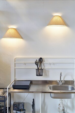 Compact kitchen with stainless steel sink, metal countertop, and modern design.