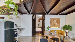 A compact kitchen with a refrigerator, sink, and a small dining area with a table and chairs.