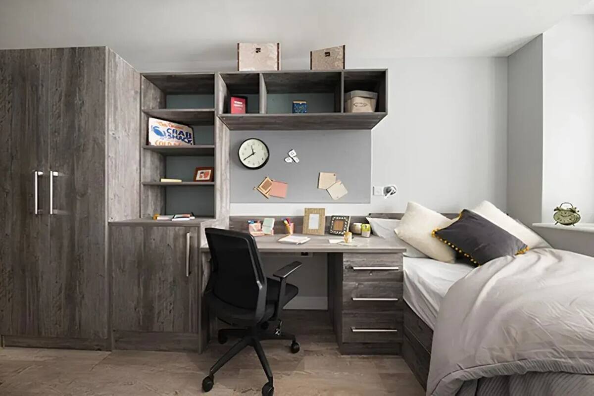Une chambre à coucher avec un lit, un bureau et une armoire.
