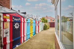 A row of colorful beach huts with a clear path between them.
