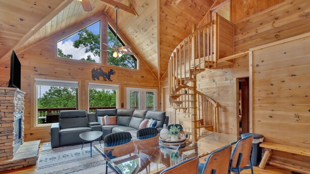 Amplia sala de estar con una chimenea moderna, una mesa de comedor de cristal y un conjunto de asientos confortable.