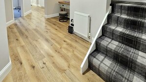 A modern interior with a wooden floor, a staircase with a plaid carpet, and a framed black and white photo on the wall. - Warm & Cosy Home in Glasgow (Glasgow)