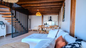 A modern interior with a wooden staircase, a dining area, and a living room with a sofa and a round wooden table. - Exclusive Hill Sapanca (Sapanca)
