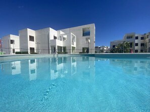 A swimming pool with a modern building in the background.