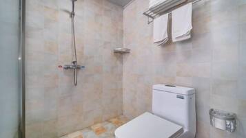 A bathroom with a toilet, a shower, and a towel rack.
