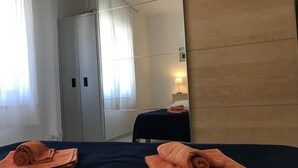 Een hotelkamer met een bed, een bureau, een stoel en een kledingkast.