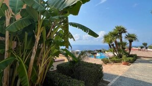 Ein Resort mit Pool, Palmen und Meerblick.