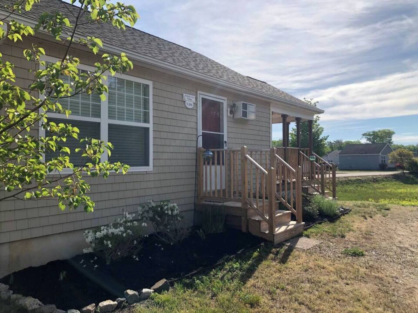 A single-story house with a front porch, a small front yard, and a driveway.