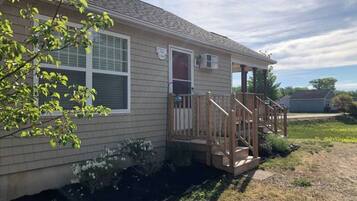 A single-story house with a front porch, a small front yard, and a driveway.