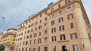 Un edificio de varios pisos con fachada simétrica, múltiples ventanas y una entrada central.