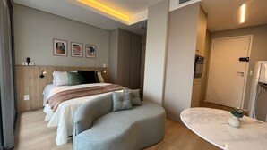 A modern hotel room with a large bed, a seating area, and a marble table. - Vossa Bossa Pop Pinheiros (São Paulo)
