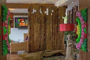 Ein Zimmer mit einer Holzwand, einer Statue und einem Fernseher an der Wand.